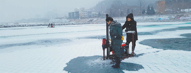 26일 강원 평창 송어축제 장소인 평창군 진부면 오대천에서 얼음낚시를 위한 구멍 뚫기 작업이 진행되고 있다. 얼음 바닥에는 
안전그물망이 설치돼 있다. 평창 송어축제는 28일 개막해 내년 2월 2일까지 열린다. 평창 송어축제위원회 제공