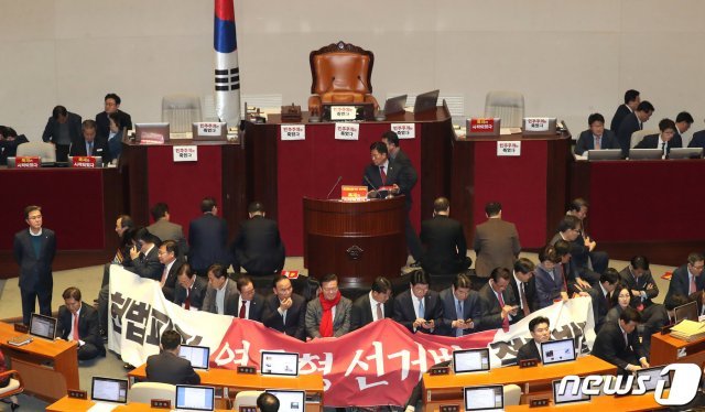 자유한국당 의원들이 27일 서울 여의도 국회 본회의장에서 제373회 국회(임시회) 제1차 본회의 개의를 막기위해 의장석을 둘러싸고 있다. 이날 국회에서는 선거법이 표결에 붙여질 예정이다. 2019.12.27/뉴스1 © News1