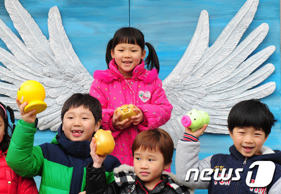 전북 전주시 노송동주민센터 앞 ‘천사의 날개’에서 저금통을 들고 서 있는 어린이들. /뉴스1