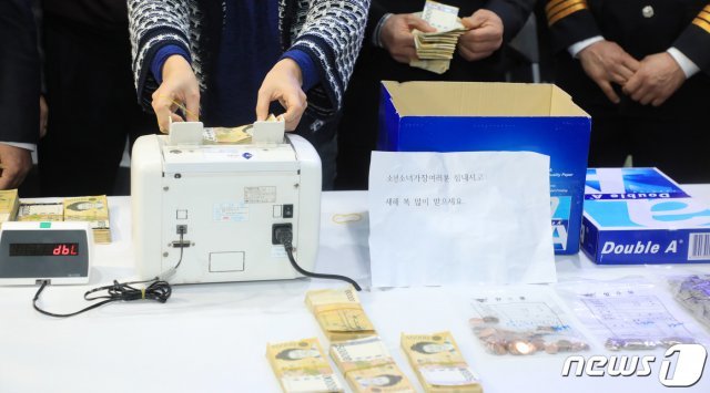 2일 전북 전주시 노송동주민센터에서 센터 관계자들이 도난당했던 ‘얼굴없는 천사’의 기부금을 경찰에게 인계받아 액수를 확인하고 있다. 얼굴없는 천사는 ‘소년소녀가장여러분 힘내시고 새해 복 많이 받으세요’라는 글과 함께 6016만 2310원의 20년째의 성금을 보내왔다. 2020.1.2/뉴스1 © News1