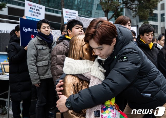 세계평화청년학생연합 소속 한·일 청년들이 2일 오후 서울 종로구 옛 일본대사관 앞에서 열린 한일청년대학생 서울평화공동선언 기자회견에서 평화의 소녀상과 포옹하고 있다. 뉴스1