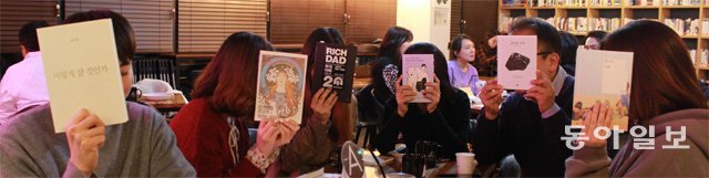 1일 서울 강남구 북카페 ‘아그레 라운지’에서 대부분 초면인 회원들이 이름만 밝힌 채 함께 독서 모임을 하고 있다. 이들이 책으로 얼굴을 가린 것은 익명 모임임을 강조하기 위해 연출한 것이다. 조건희 기자 becom@donga.com