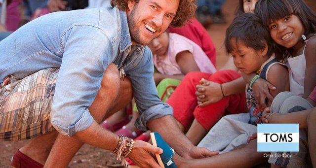 블레이크 마이코스키 탐스슈즈 창업자(왼쪽)가 개발도상국 아이들에게 기부된 신발을 신겨주고 있다(탐스슈즈 홈페이지 캡처).