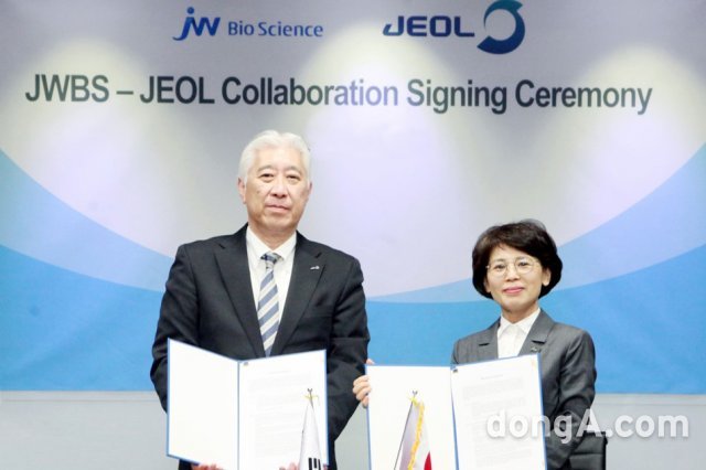 함은경 JW바이오사이언스 대표(오른쪽)와 사이토 신 제올 의료기기사업운영 총책임자가 계약서에 서명한 후 기념촬영을 하고 있다.