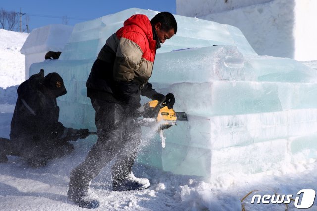 기온이 영하 10도까지 떨어진 15일 오전 강원 인제군 빙어호 일원에 근로자들이 인공눈과 얼음을 이용해 빙어축제장을 조성하느라 분주하다. © News1