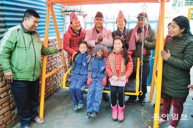 13일 네팔 카트만두 인근의 바드라칼리 초등학교의 놀이터에 설치된 그네를 탄 네팔 어린이들이 즐거워하고 있다.