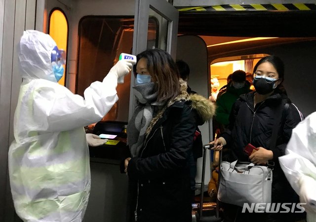 보호복을 입은 보건 관계자들이 22일 중국 베이징 공항에서 우한시에서 도착한 승객들의 체온을 체크하고 있다. 중국은 신종 코로나바이러스로 발생하는 우한 폐렴의 확산을 막기 위해 23일부터 모든 항공기와 열차들의 우한 출발을 막기 시작했다. 2020.1.23. 사진=뉴시스