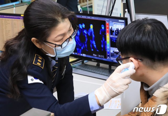 24일 오전 인천국제공항 제1여객터미널을 통해 입국하던 한 여행객이 열화상카메라에 감지돼 방역당국 직원이 체온을 확인하고 있다. 이날 질병관리본부는 55세 한국인 남성이 국내 두 번째 우한 폐렴(신종 코로나바이러스) 확진환자로 확인됐다고 밝혔다. 이로써 우한폐렴 국내 확진환자는 1명에서 2명으로 늘었다./뉴스1 © News1