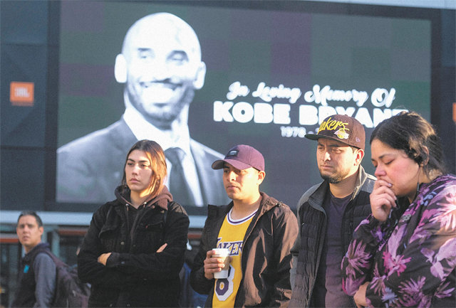 코비 브라이언트를 기리는 팬들이 28일 LA 레이커스의 홈구장인 미국 캘리포니아주 로스앤젤레스의 스테이플스센터 인근에 마련된 추모 공간 앞에서 ‘전설의 스타’를 애도하고 있다. 로스앤젤레스=AP 뉴시스