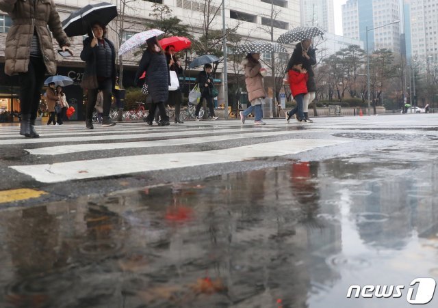 수도권 지역에 겨울비가 내린 지난 7일 오후 서울 양천구 축제의 거리 앞에서 우산을 쓴 시민들이 발걸음을 옮기고 있다. 2020.1.7/뉴스1 © News1
