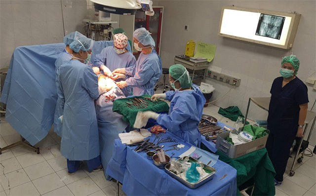 김인권 예스병원 원장(가운데)이 라오스 의사 캄반 반살리시(흰 모자)에게 인공엉덩관절 수술법을 지도하고 있다. 서울대 의대 제공