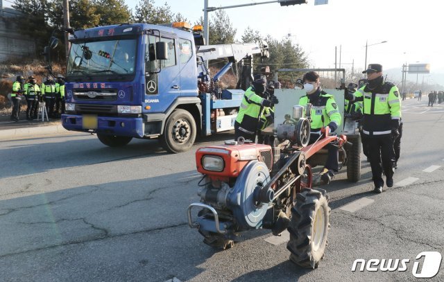 (아산=뉴스1) 김기태 기자 = 30일 오전 중국 우한에서 귀국하는 교민들이 수용될 충남 아산 경찰인재개발원 앞 도로에서 주민들이 막아 놓은 농기계를 경찰관들이 이동하고 있다. 신종 코로나바이러스 감염증(우한 폐렴) 발원지인 중국 후베이성 우한에서 전세기로 귀국하는 교민들은 충남 아산 경찰인재개발원과 충북 진천의 공무원인재개발원에 나눠 격리 수용될 예정이다. 2020.1.30/뉴스1