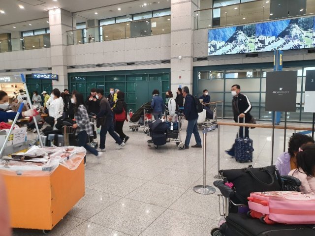 인천공항 제1여객터미널 국제선 입국장에 모습을 드러낸 사람들. 다들 하나같이 마스크를 쓰고 있다. © 뉴스1
