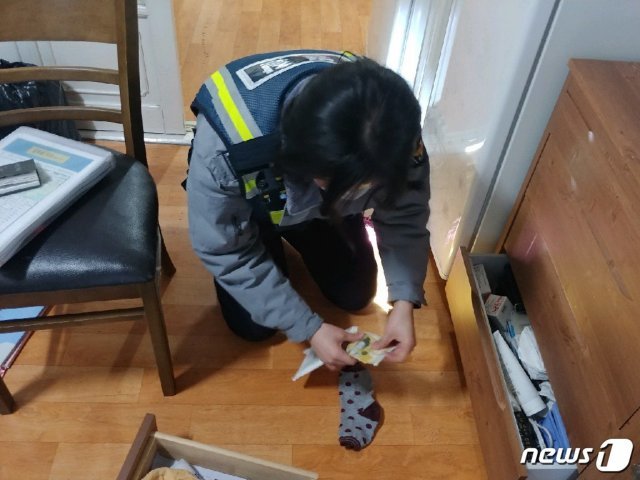 지난 29일 오후 부산 북구 금곡동의 한 주거지에서 김새봄 순경이 70대 할머니 A씨가 잃어버린 돈봉투를 찾고난 뒤 금액을 확인하고 있다.(부산지방경찰청 제공)© 뉴스1