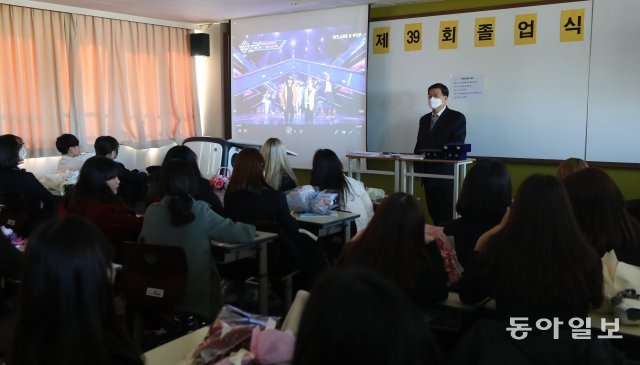 담임 선생님이 마스크를 쓰고 식을 진행하고 있다.