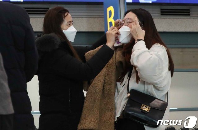 4일 인천국제공항 제1터미널 입국장에서 여행객을 마중나온 가족이 신종 코로나바이러스 감염증 확진을 예방하기 위해 마스크를 씌워주고 있다. 2020.2.4/뉴스1 © News1