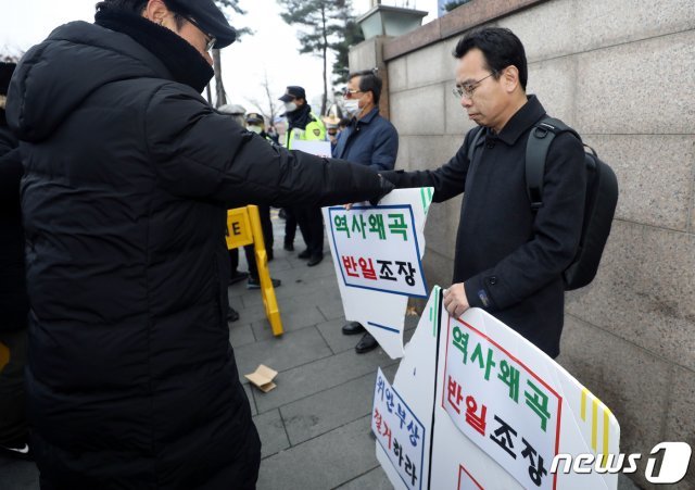 ‘반일종족주의’ 저자 이우연 낙성대경제연구소 연구위원이 지난해 12월서울 종로구 옛 일본대사관 앞에서 수요시위 중단과 소녀상 철거를 주장하며 한 시민이 걷어차 부서진 피켓을 든 채 1인 시위를 벌이고 있다. 2019.12.11/뉴스1 © News1