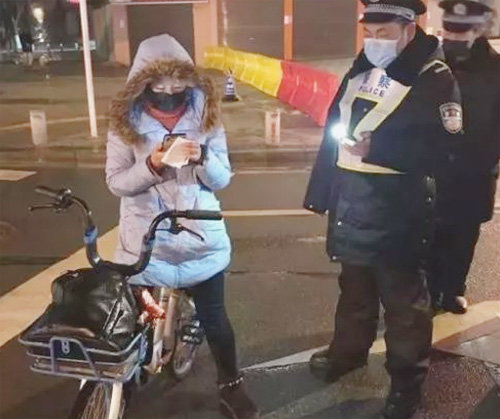 중국 후베이성 우한시 보건소 의사인 간루이 씨(왼쪽)가 자전거를 타고 보건소로 돌아가던 중 경찰과 대화하고 있다. 사진 출처 창장일보