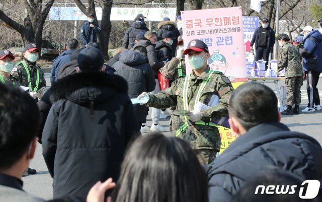 3일 오후 충남 논산 육군훈련소 입영심사대 앞에서 군인장병이 입영장병들에게 마스크를 나누주고 있다. 신종 코로나바이러스 확산 방지 차원에서 육군훈련소는 예정된 입영행사를 취소했다. 2020.2.3/뉴스1 © News1