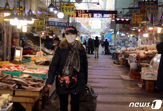 7일 오후 광주 서구 양동시장에서 한 시민이 마스크를 쓰고 지나가고 있다. © 뉴스1