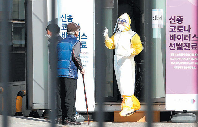 9일 서울 중구 국립중앙의료원 선별진료소 앞에서 방역복을 입은 의료진이 한 시민을 안내하고 있다. 이날 신종 코로나 확진 환자는 3명이 추가돼 총 27명이 됐다. 뉴스1
