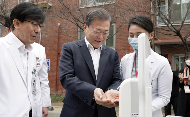 문재인 대통령이 지난달 28일 오전 신종 코로나바이러스 감염증 대응 의료기관인 서울 중구 국립중앙의료원에 도착해 선별진료소 대기실 앞에 설치된 소독제로 손을 소독하고 있다. 청와대제공