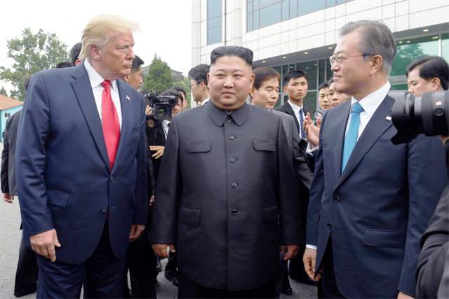 지난해 6월 30일 판문점에서 문재인 대통령, 김정은 북한 국무위원장, 도널드 트럼프 미국 대통령(오른쪽부터)이 3자 회동 장소인 ‘자유의 집’ 앞에서 함께 서 있다. AP 뉴시스
