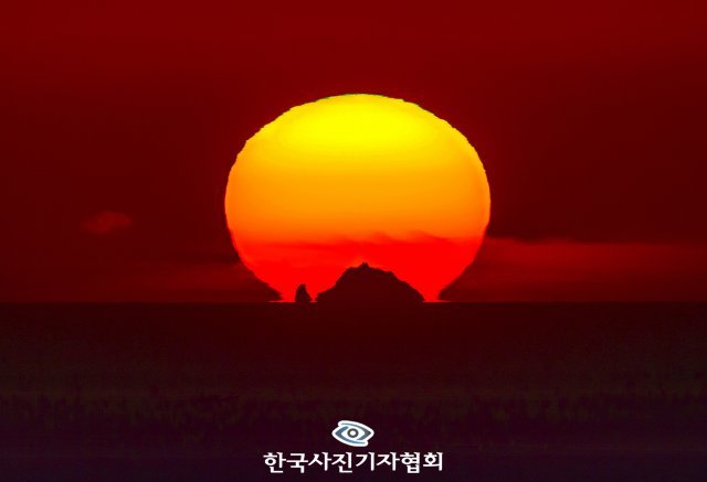 신경림 시인은 이곳을 가리켜 ‘홀로 있어도 늘 우리들 가슴 한복판에 있는… 영원한 그리움이고 안타까움’이라고 했습니다. 이곳은 독도입니다. 독도를 품은 태양의 사진을 카메라에 담았습니다. 울릉도에서 남동쪽으로 87.4㎞ 떨어진 독도를 볼 수 있는 날은 1년에 50일 남짓, 독도와 태양을 일직선으로 볼 수 있는 때는 2월과 11월 중 열흘 정도에 불과합니다. 한 달 간의 취재 끝에 대한민국에서 가장 먼저 해가 떠오르는 독도의 ‘황금 일출’ 장면을 포착할 수 있었습니다.
＜국민일보/윤성호기자＞