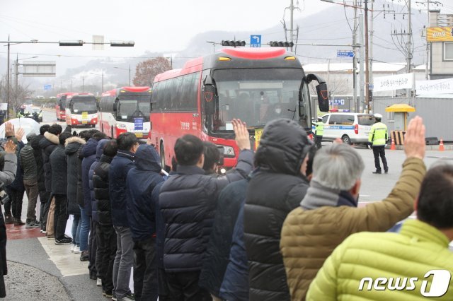 16일 오전 충남 아산시 경찰인재개발원에서 코로나19(신종코로나)사태로 인해 2주간 격리생활을 마친 2차 입국 우한 교민들이 버스를 타고 퇴소하고 있다. 아산시 주민들이 퇴소하는 교민들을 배웅하고 있다. © News1