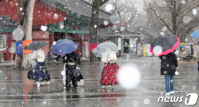 눈이 내린 16일 전북 전주시 한옥마을 찾은 관광객들이 우산을 쓰고 눈 내리는 거리를 걷고 있다. 2020.2.16/뉴스1 © News1