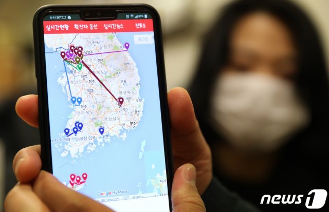 서울 도심에서 한 시민이 스마트폰 애플리케이션을 이용해 실시간 국내 감염자 확진자 동선을 살펴보고 있다. © News1
