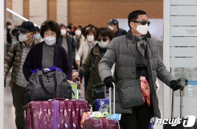 신종 코로나 바이러스 국내 확진자가 24명으로 늘어나 확산 우려가 커지던 지난 7일 오후 인천국제공항 제2터미널 입국장에 마스크를 쓴 인파로 붐비고 있다. 2020.2.7/뉴스1 © News1