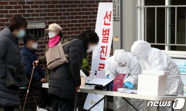 21일 오전 서울 종로구 보건소 선별진료소에서 보건당국 관계자들이 신종 코로나바이러스 감염증(코로나19) 의심 증상으로 보건소를 찾아온 시민들의 체온을 확인하고 있다. © News1
