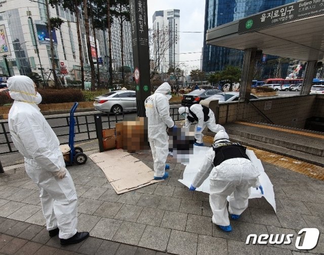 21일 서울 지하철 2호선 을지로입구역의 3번 출구 인근에서 노숙인 1명이 숨진 채 발견돼 경찰이 시신을 수습하고 있다. © 뉴스1