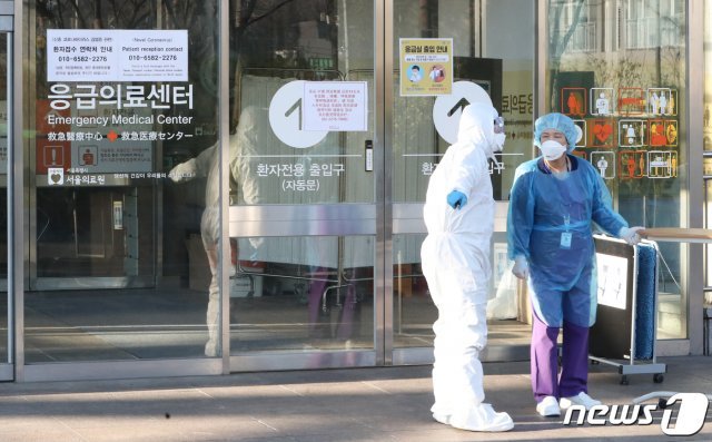신종 코로나바이러스 감염증(코로나19) 국가지정입원치료병상이 마련된 서울 중랑구 서울의료원 선별진료소 앞에서 의료진이 분주히 움직이고 있다. 뉴스1