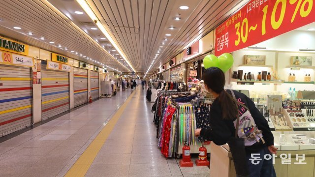 코로나 감염 우려로 지하 상가에 방문객들이 끊기자 23일 오후 서울 종각역 지하쇼핑센터 점포들이 문을 닫고 영업을 하지 않고 있다. 한 상인이 손님을 기다리고 있다.