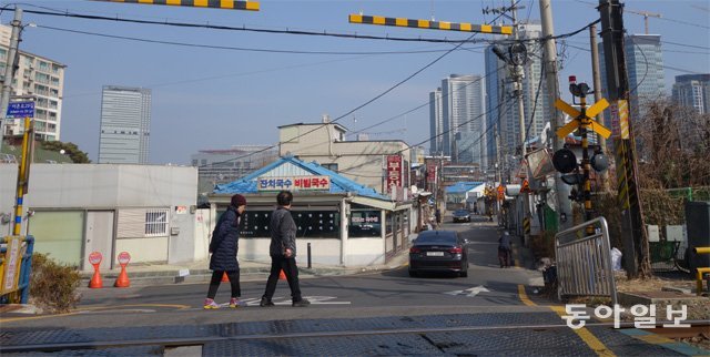 서울 용산구 ‘땡땡거리’에 놓인 두 개의 철길 건널목 중 한 곳을 주민들이 지나고 있다. 뒤로 드라마 ‘블랙독’의 촬영 장소인 국숫집이 보인다. 박창규 기자 kyu@donga.com