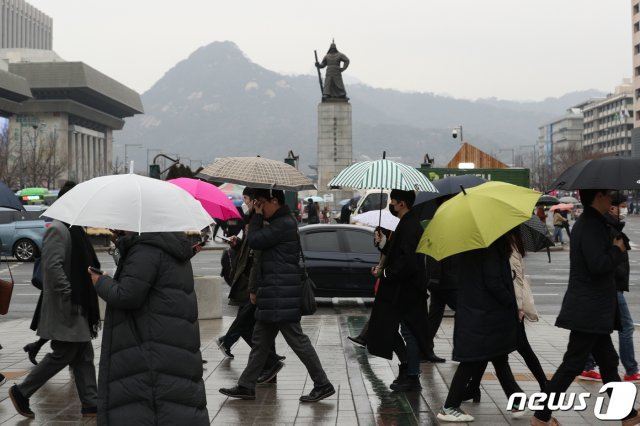 서울 광화문광장 앞 사거리에서 우산을 쓴 시민들이 출근길 발걸음을 재촉하고 있다. /뉴스1 © News1