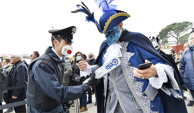 베네치아 카니발도 코로나에 중단 23일 이탈리아 베네치아의 한 경찰관이 마스크를 쓴 채 카니발 참가자의
 몸을 금속탐지기로 검사하고 있다. 이탈리아 전역에서 신종 코로나바이러스 감염증(코로나19) 환자가 속출하자 베네치아 당국은 
8일부터 진행 중이던 이탈리아 최대 축제 ‘베네치아 카니발’을 23일 중단시켰다. 베네치아=AP 뉴시스