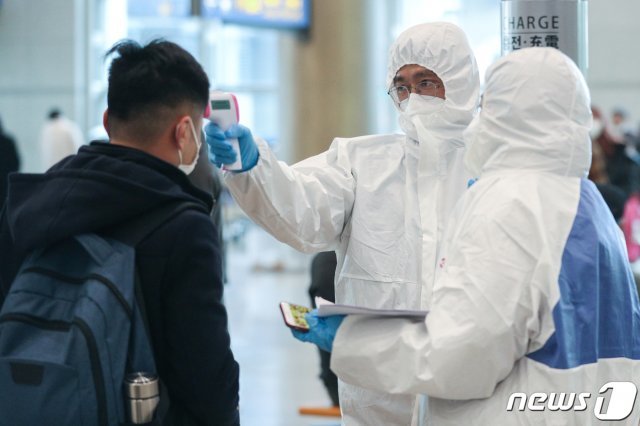 신종 코로나바이러스감염증(코로나19) 확산세가 급증하고 있는 25일 오후 중국인 유학생들이 인천국제공항 입국장을 통해 입국해 대학 관계자로부터 체온 검사를 받고 있다. 2020.2.25/뉴스1 © News1