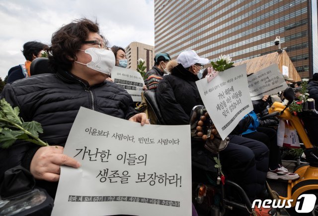 기초법바로세우기공동행동 등 시민단체 회원들이 26일 오후 서울 세종대로 광화문광장에서 열린 송파 세모녀 6주기 및 가난 때문에 세상을 떠난 이들의 추모 기자회견에서 손 피켓을 들고 있다. © News1