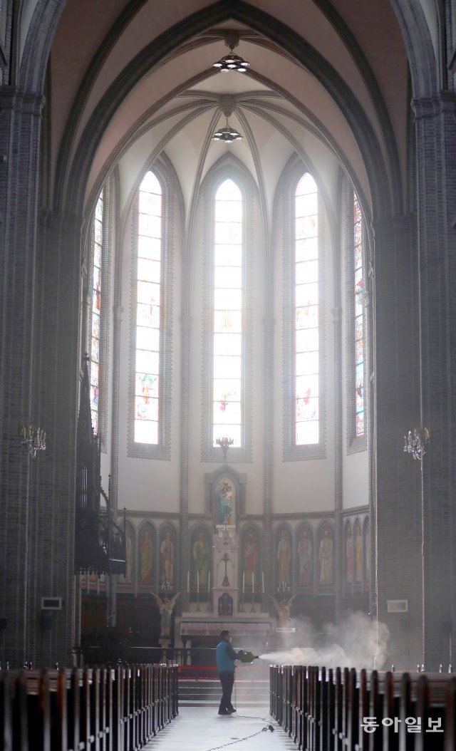 명동 성당에 미사가 멈춘 날
코로나19 확산으로 천주교 서울대교구가 지난 1831년 교구 설립 이래 처음으로 미사를 전면 중단한 가운데 26일 서울 중구 명동성당에서 한 관계자가 방역 작업을 하고 있다.