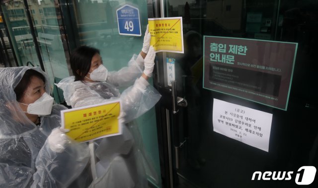 25일 울산시청 공무원들이 남구 무거동 신천지 울산교회 출입문에 폐쇄명령서를 붙이고 있다. © News1