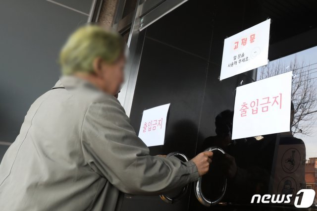 국내 31번째 확진자가 다녔던 대구 남구 대명동 신천지 대구교회를 찾은 신도가 굳게 잠긴 문을 흔들고 있다. 2020.2.19/뉴스1 © News1