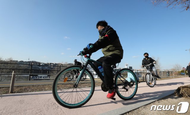 서울 강남구 한강공원을 찾은 시민들이 마스크를 쓴 채 자전거를 타고 즐기고 있다. © News1
