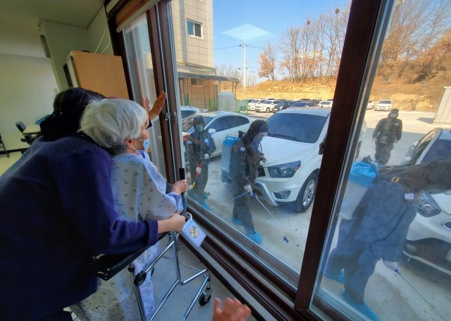 경북 예천군 경도요양병원 입원환자들이 50사단 장병들로 구성된 육군 현장지원팀의 방역활동에 응원을 보내고 있다.＜사진제공 육군＞