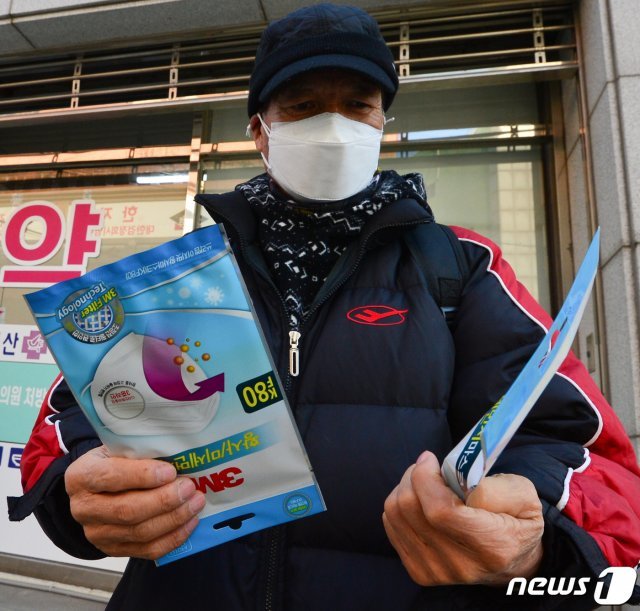 5일 오전 경북 포항시 남구 연일읍에 있는 한 약국에서 마스크를 구입한 시민이 내용물을 확인하고 있다. 포항시는 이날 공적 마스크를 관내 약국에서 판매를 시작한다. © News1