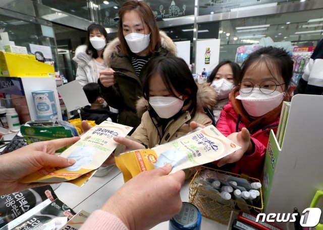 신종 코로나바이러스 감염증(코로나19) 확진자가 6700명을 넘어선 7일 오후 경기도 수원시 권선구의 금곡동의 한 약국 앞에서 아이들이 마스크 구입을 하고 있다.2020.3.7/뉴스1 © News1