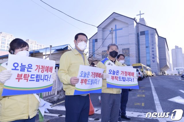 이용섭 광주광역시장이 8일 오전 서구 한 교회 정문앞에서 서대석 서구청장 및 직원들과 코로나19 집단감염 방지를 위해 피켓을 들고 집단예배 자제를 호소하고 있다.(광주시 제공)2020.3.8 /뉴스1 © News1