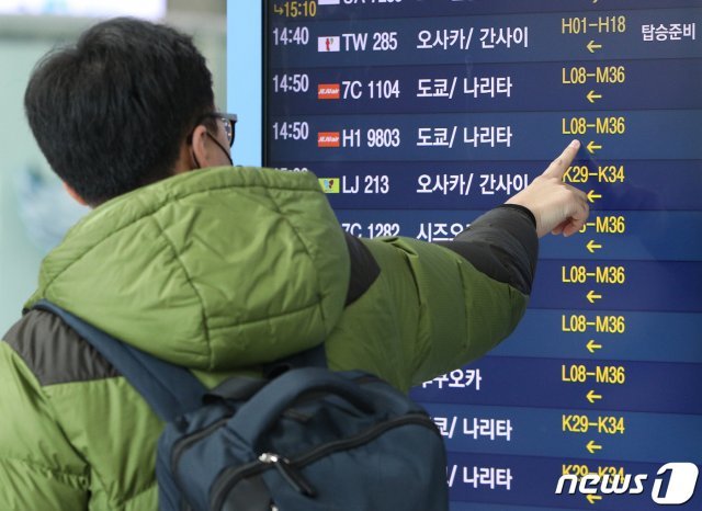 8일 오후 인천국제공항 1터미널 출국장에서 탑승객들이 일본행 비행편을 확인하고 있다. 2020.3.8/뉴스1 © News1